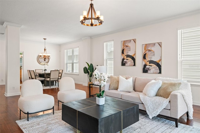 living room with crown molding, a chandelier, and wood-type flooring