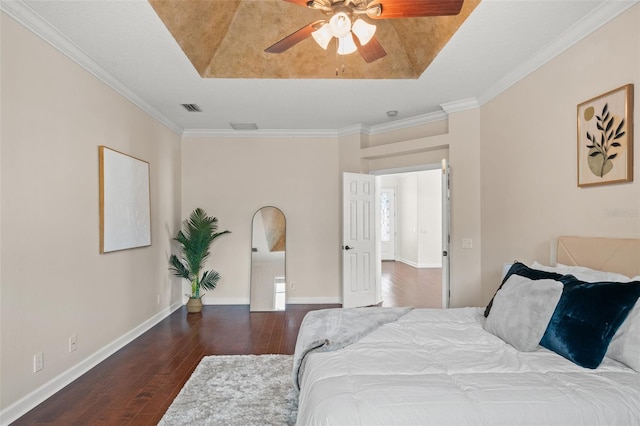 bedroom with ceiling fan, dark hardwood / wood-style flooring, a raised ceiling, and crown molding