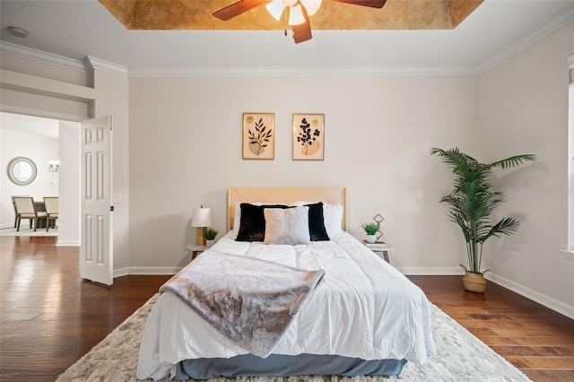 bedroom featuring ceiling fan, crown molding, and dark wood-type flooring