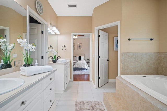 bathroom with tile patterned floors, tiled bath, ceiling fan, and vanity