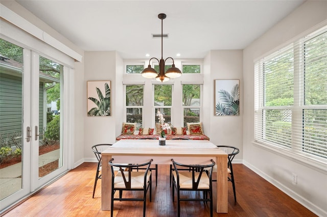 dining space featuring hardwood / wood-style floors and a notable chandelier