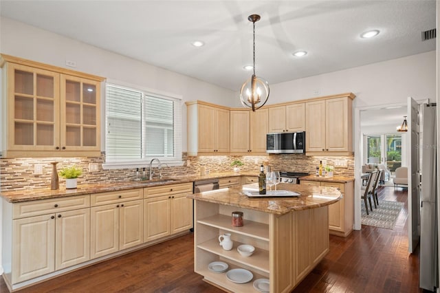 kitchen with sink, hanging light fixtures, a kitchen island, dark hardwood / wood-style flooring, and stainless steel appliances