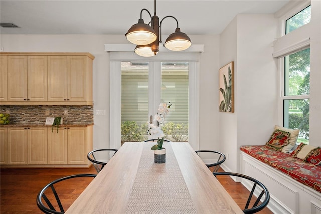 dining space featuring dark hardwood / wood-style floors and a chandelier