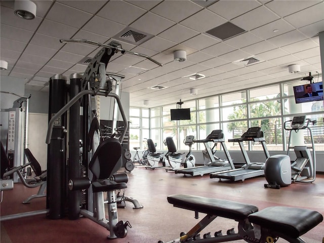 workout area with a drop ceiling and expansive windows