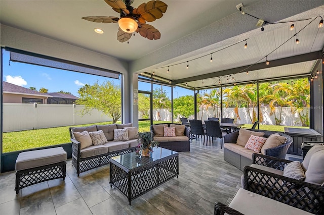 sunroom with track lighting, ceiling fan, and a healthy amount of sunlight