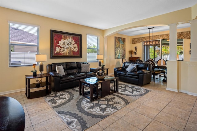 tiled living room featuring plenty of natural light and a chandelier