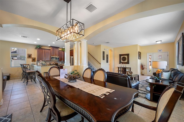 tiled dining room with a chandelier