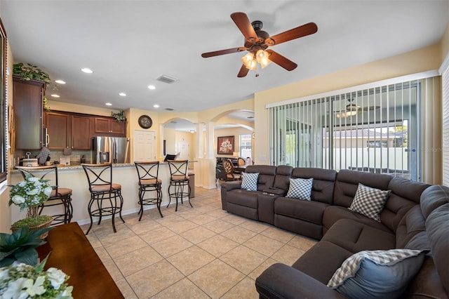 tiled living room with ceiling fan