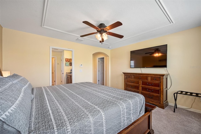 bedroom featuring carpet floors, ensuite bathroom, and ceiling fan