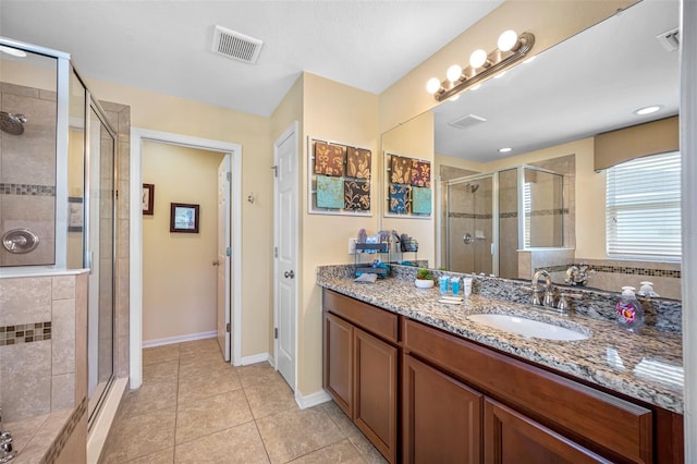 bathroom with vanity, tile patterned floors, and a shower with door