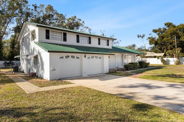 view of property with central air condition unit, a front lawn, and a garage