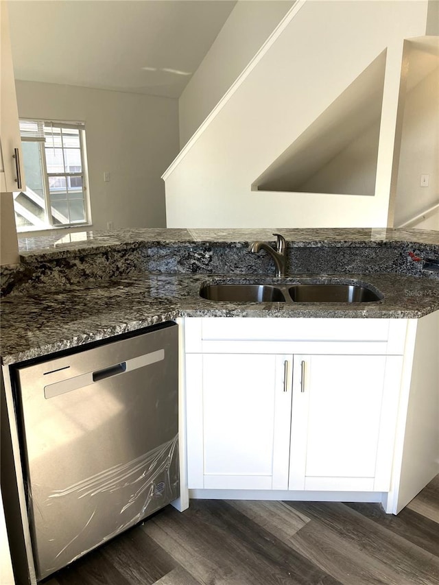 kitchen featuring white cabinetry, dishwasher, sink, dark hardwood / wood-style flooring, and dark stone countertops