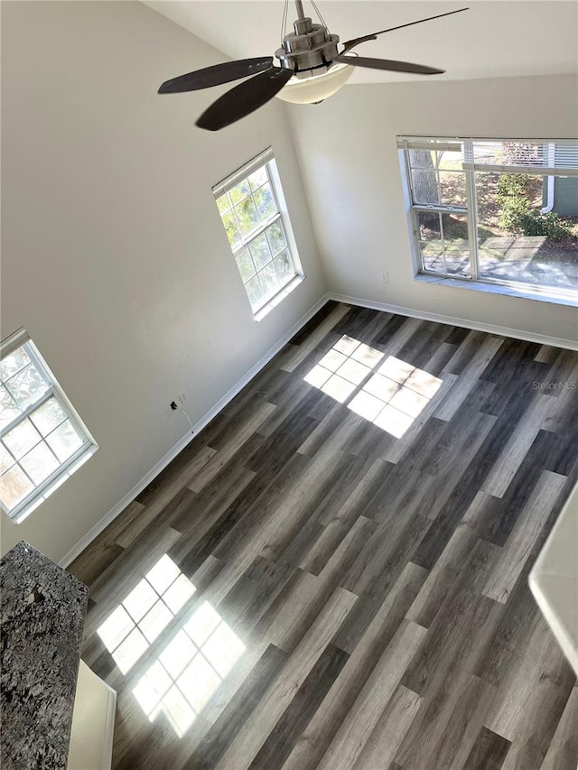 unfurnished room featuring ceiling fan, dark hardwood / wood-style flooring, and a healthy amount of sunlight