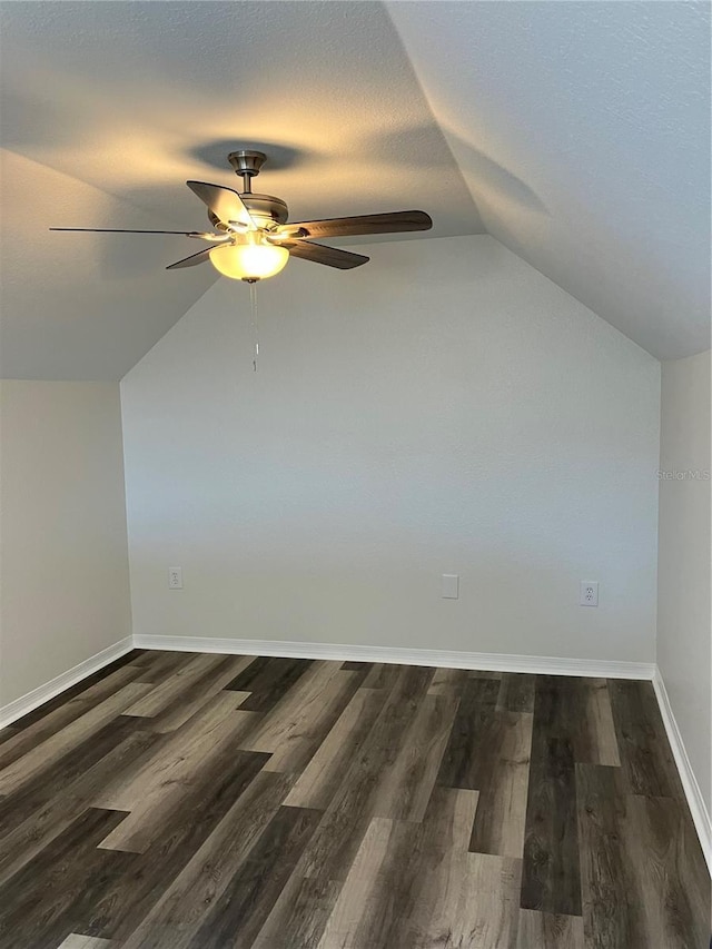 additional living space featuring dark hardwood / wood-style floors, vaulted ceiling, and ceiling fan