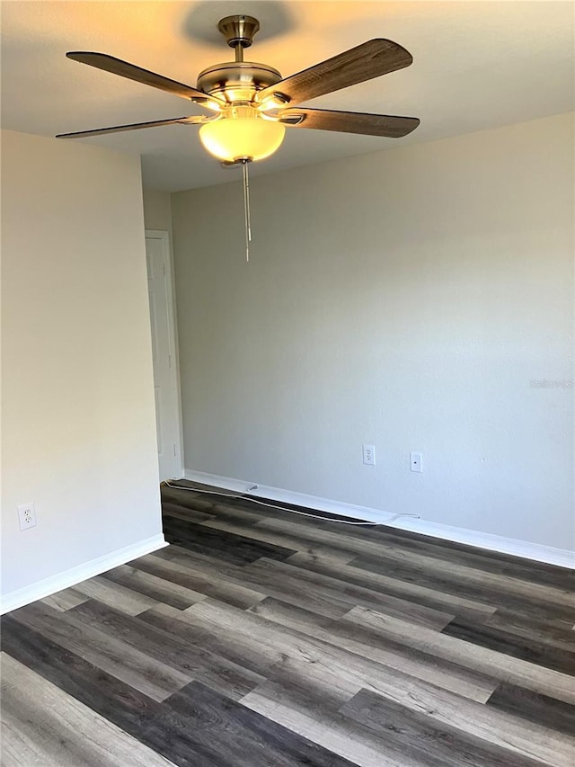 spare room featuring ceiling fan and dark wood-type flooring