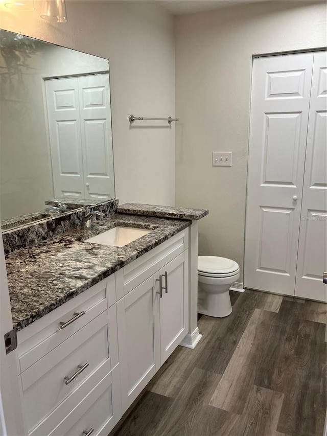 bathroom with hardwood / wood-style flooring, vanity, and toilet