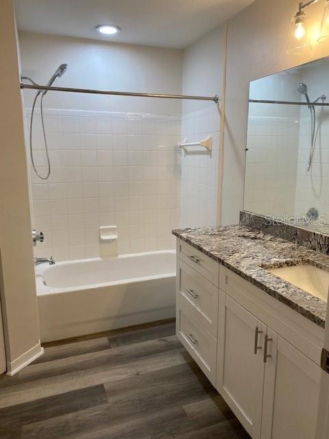 bathroom featuring vanity, hardwood / wood-style flooring, and tiled shower / bath combo