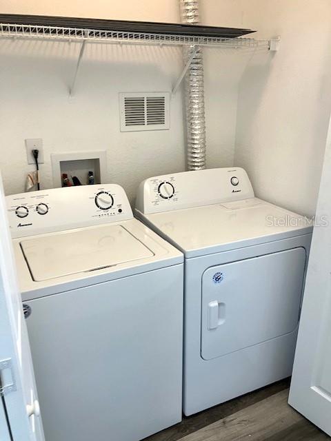 laundry room featuring dark hardwood / wood-style floors and separate washer and dryer