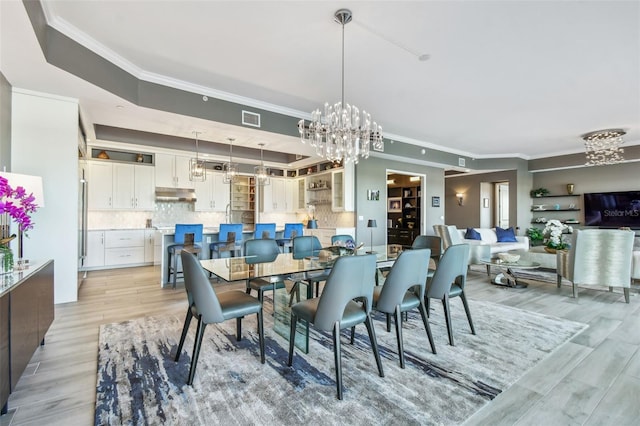 dining area featuring crown molding, a notable chandelier, and light wood-type flooring