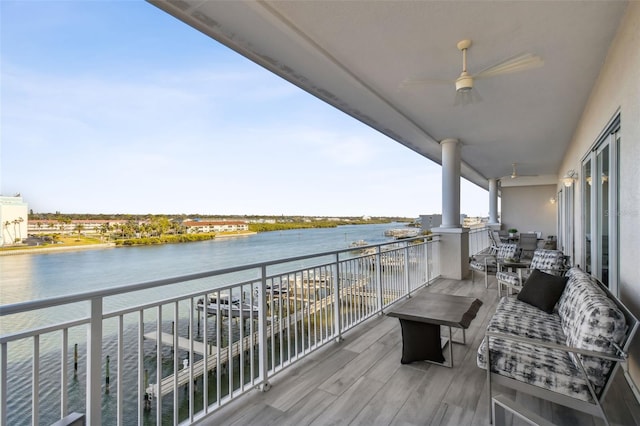 balcony with ceiling fan and a water view