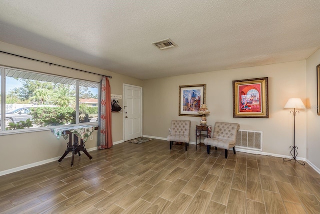 living area featuring light wood-style floors, visible vents, and baseboards