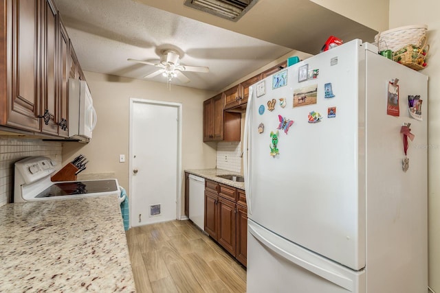 kitchen with visible vents, decorative backsplash, a ceiling fan, light wood-type flooring, and white appliances