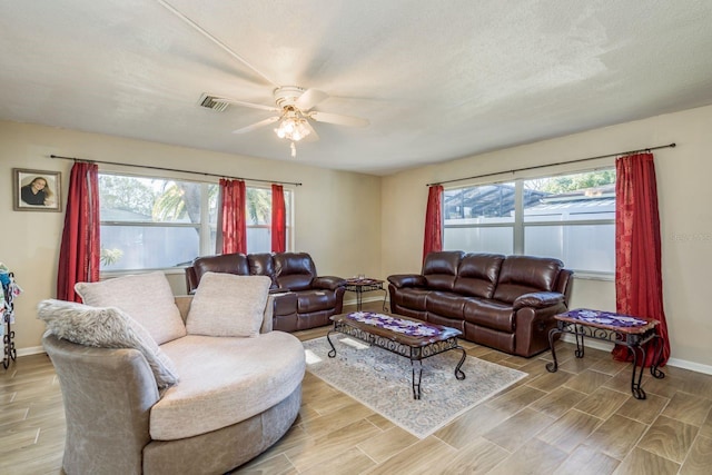 living room with baseboards, wood finish floors, visible vents, and a healthy amount of sunlight