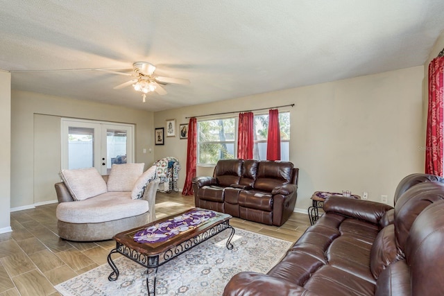 living area with baseboards, a ceiling fan, french doors, a textured ceiling, and wood finish floors