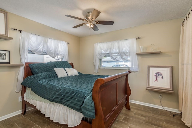 bedroom with wood tiled floor, baseboards, ceiling fan, and a textured ceiling