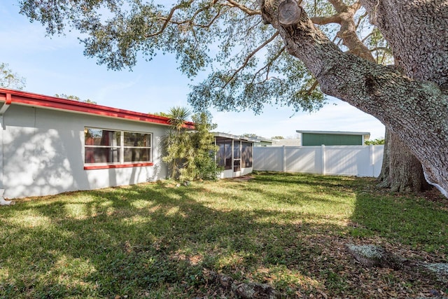 view of yard featuring a sunroom and fence