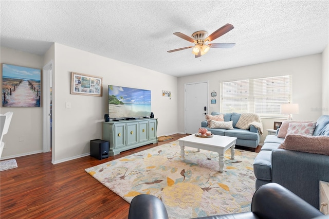 living room featuring a textured ceiling, ceiling fan, and dark wood-type flooring