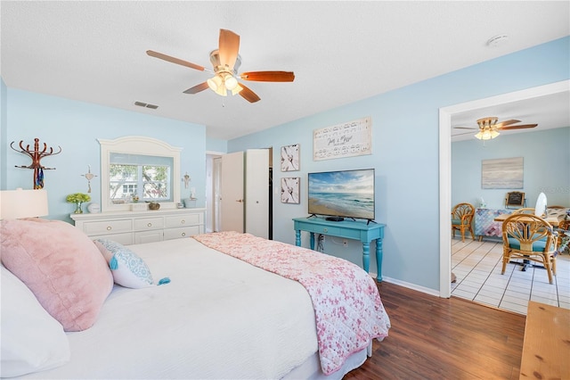 bedroom featuring ceiling fan, dark hardwood / wood-style floors, and a textured ceiling