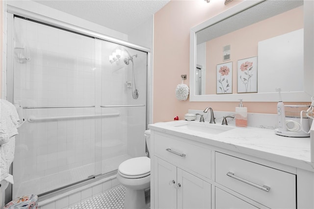 bathroom with vanity, tile patterned flooring, toilet, a textured ceiling, and a shower with shower door