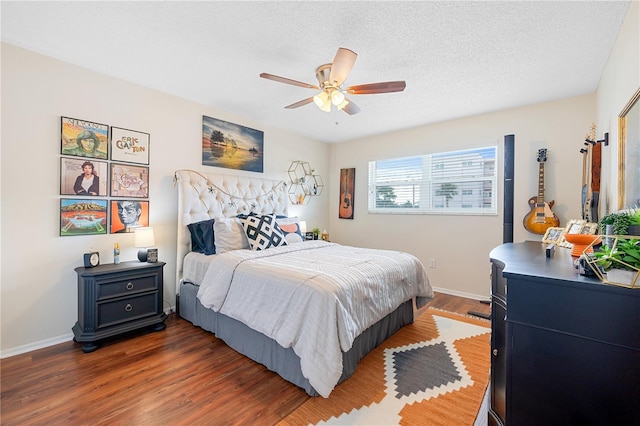 bedroom with a textured ceiling, ceiling fan, and dark wood-type flooring