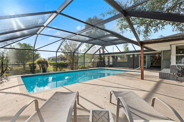 view of pool with glass enclosure and a patio area