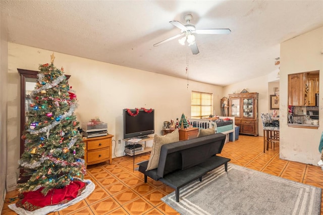 living room with ceiling fan and a textured ceiling