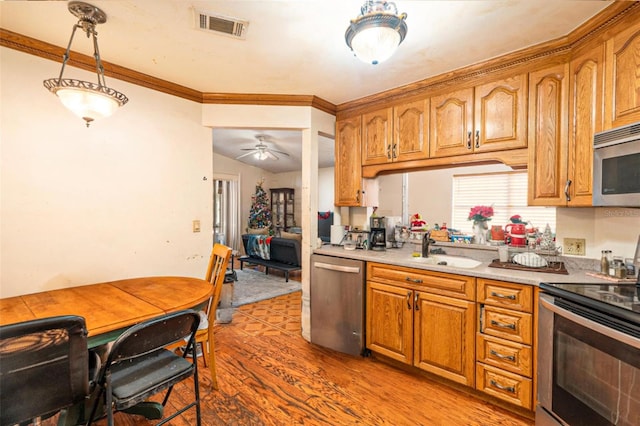 kitchen featuring stainless steel appliances, sink, hardwood / wood-style flooring, ornamental molding, and ceiling fan