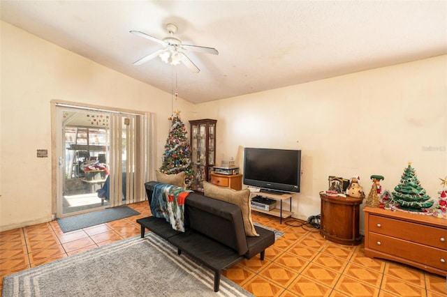 living room with ceiling fan, light tile patterned floors, and vaulted ceiling