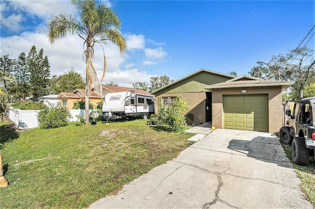 view of front facade featuring stucco siding, driveway, fence, a front yard, and a garage