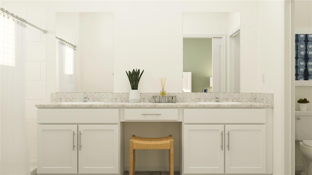 bathroom with vanity, toilet, and plenty of natural light