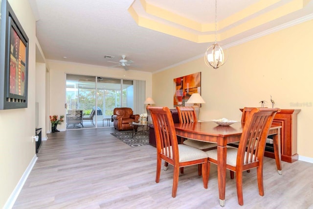 dining area featuring ceiling fan with notable chandelier, light hardwood / wood-style floors, and ornamental molding