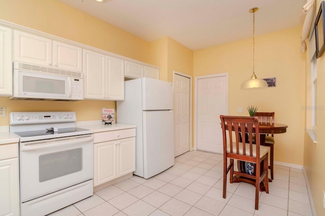 kitchen featuring light tile patterned floors, white appliances, decorative light fixtures, and white cabinetry