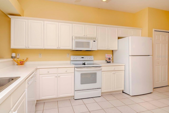 kitchen featuring white cabinets, light tile patterned floors, and white appliances