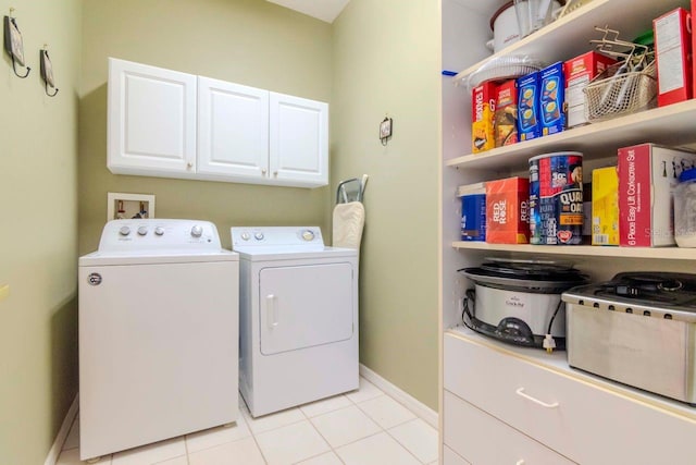 laundry room featuring cabinets, washing machine and dryer, and light tile patterned floors