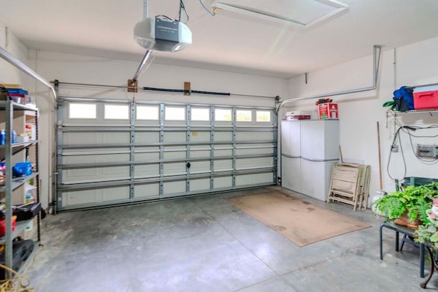 garage with white fridge and a garage door opener