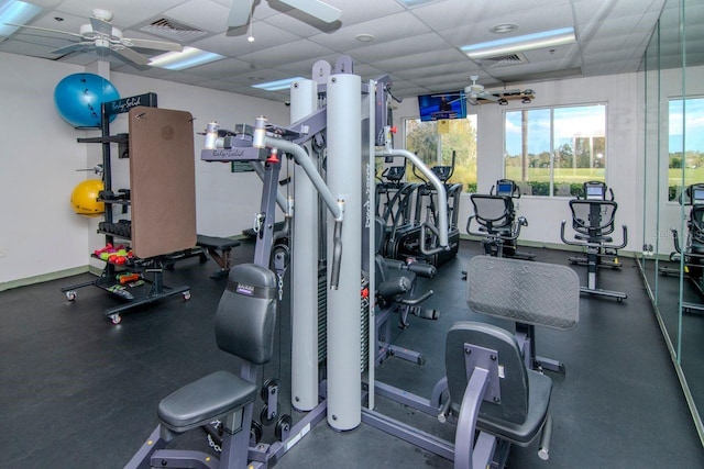 exercise room with a paneled ceiling and ceiling fan