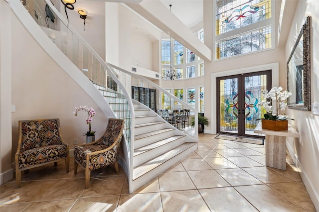 entrance foyer with light tile patterned floors, french doors, and a high ceiling