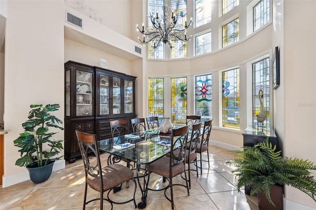 dining room with light tile patterned flooring, a towering ceiling, and a wealth of natural light