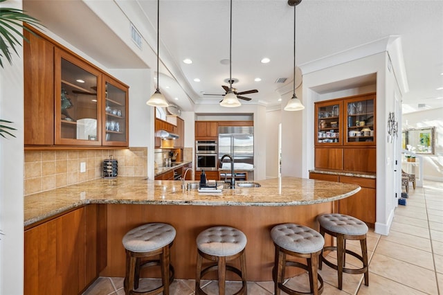 kitchen featuring pendant lighting, stainless steel appliances, tasteful backsplash, and kitchen peninsula