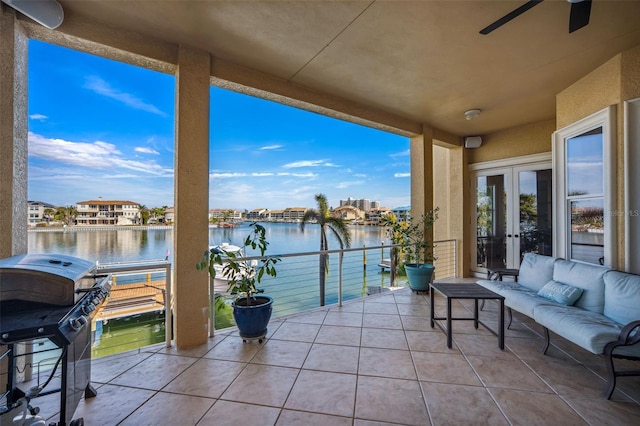 balcony with french doors, area for grilling, a water view, ceiling fan, and an outdoor living space